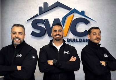 SWC Builders leadership team standing in front of the company logo
