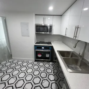 Wide view of the finished bathroom, showing the harmony between the tiling, fixtures, and lighting.