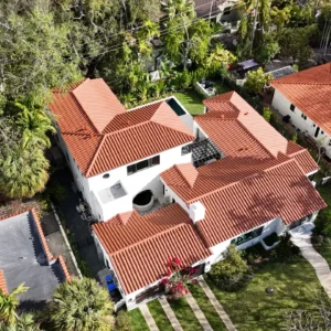 Wide shot of the Coral Gables residence under renovation, highlighting the scale of the roofing and structural work.