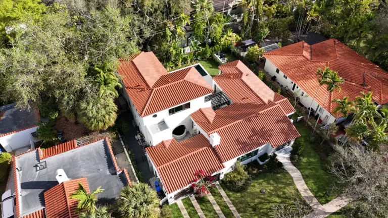 Wide shot of the Coral Gables residence under renovation, highlighting the scale of the roofing and structural work.