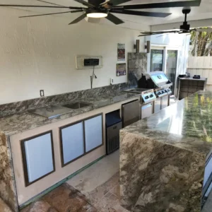 Shot showing the integration of high-end outdoor kitchen appliances within the new metal structural frame in Doral.