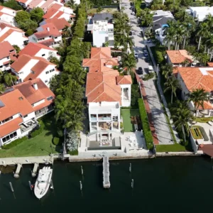 High-altitude drone view of the expansive clay tile roof and surrounding lush landscaping of the Coconut Grove property.