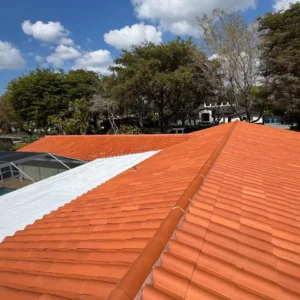 Shot highlighting the professional restoration of a flat roof section integrated with the barrel tile system in Pinecrest.